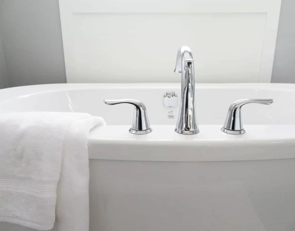 A white bathtub with a silver faucet attached